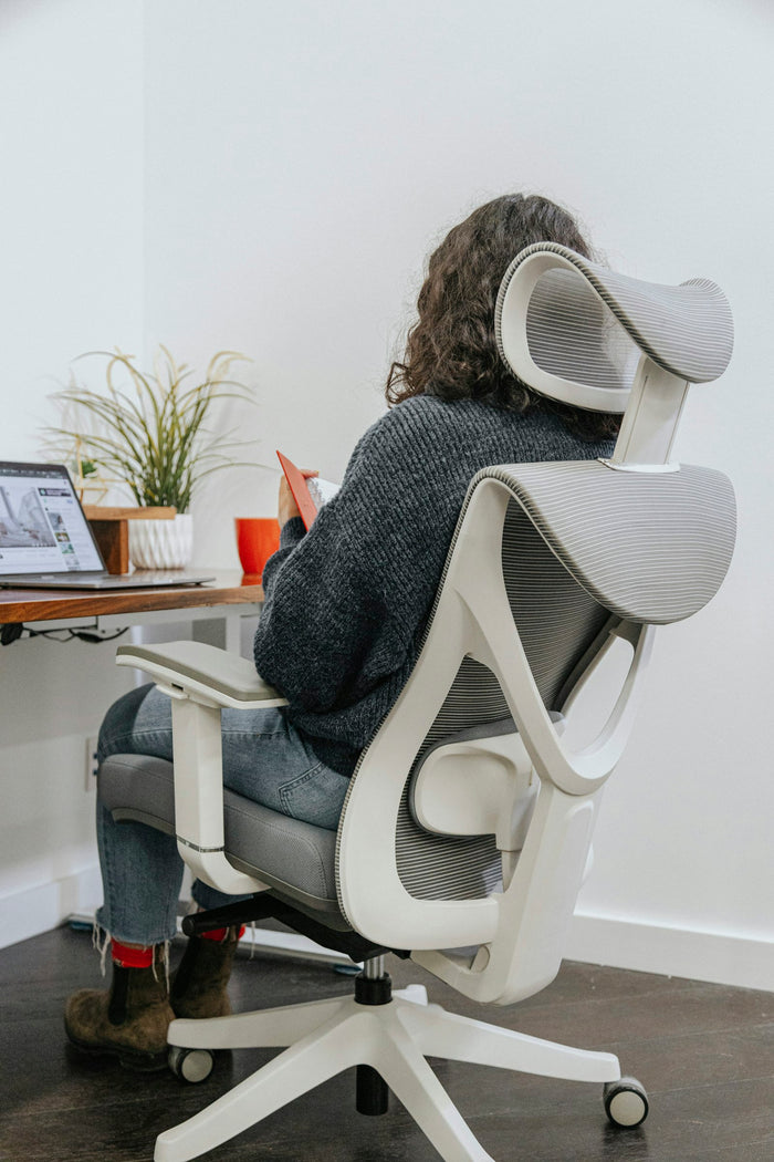 Woman sitting with good posture in an ergonomic office chair at her desk