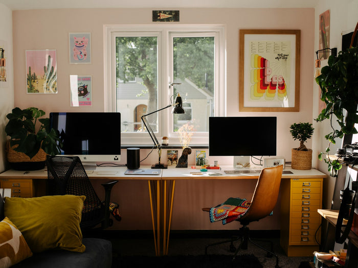 A desk with two computer monitors and a chair